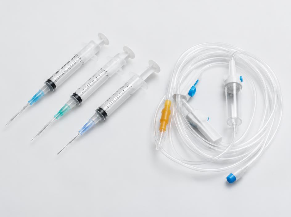 Sterile syringes and IV tubing arranged on a clinical surface